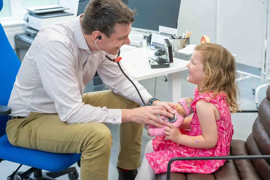 Doctor listening to a child's chest during a clinic appointment